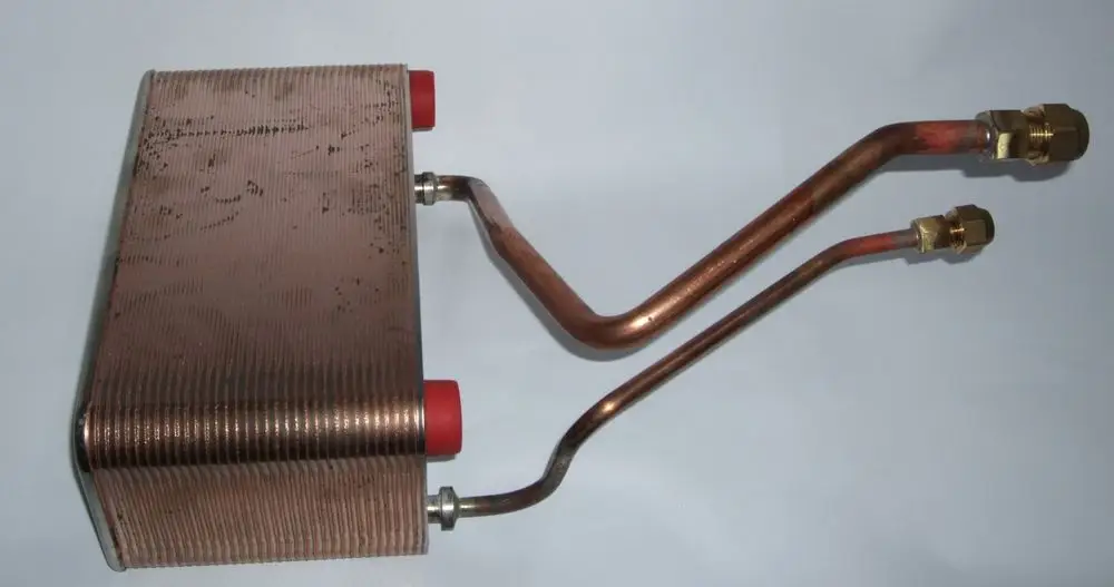 Kupferner Plattenwärmetauscher mit zwei Anschlüssen. Die Oberfläche ist gerillt und es sind zwei abgewinkelte Rohre sichtbar. Eignet sich für Daikin Systeme.